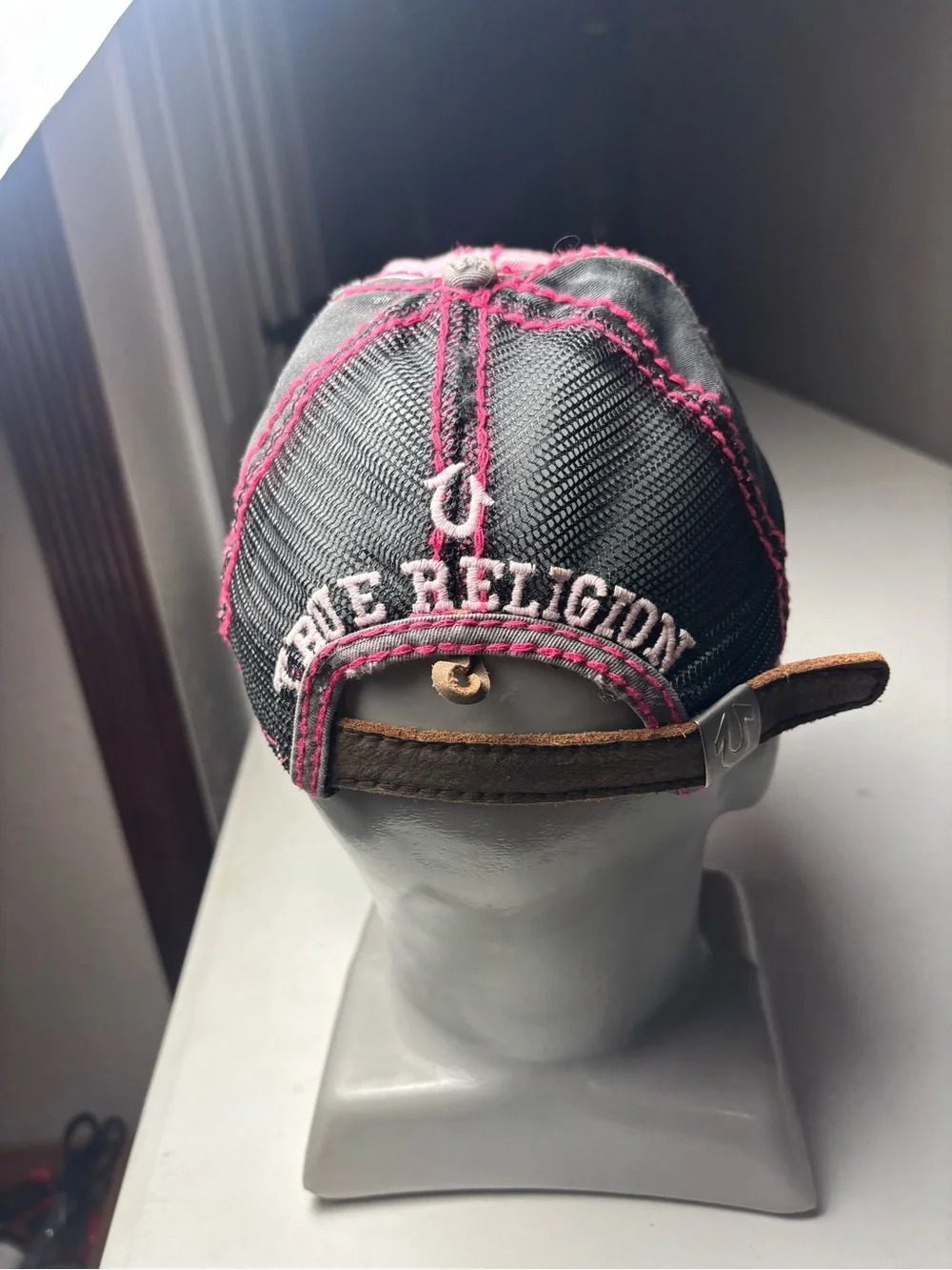 pink, distressed True Religion brand jeans cap with embroidered wings and a logo